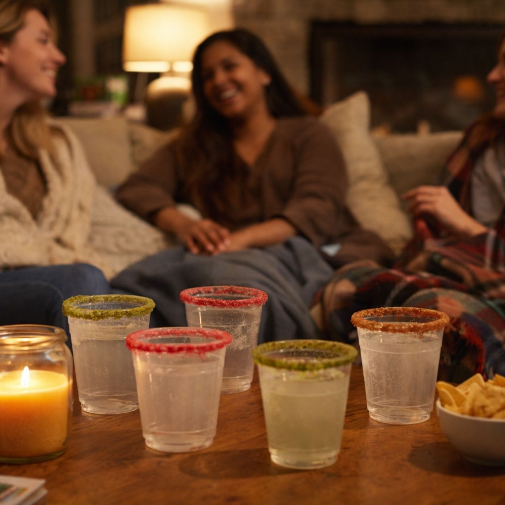 Friends relaxing together during a cozy winter girls’ night with drinks on the table