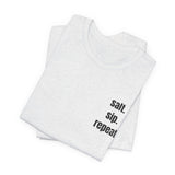 A folded light heather gray t-shirt with the words 'salt. sip.