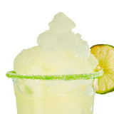 Glass of lime-flavored slushie with a lime wedge on a white background